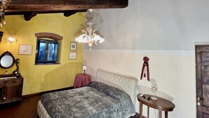 A bedroom with a bed, a small table, a mirror, and a chandelier. - House / Villa - Quarrata with private pool (Quarrata)