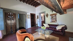 A living room with a glass coffee table, a leather sofa, a wooden floor, and a staircase leading to another room. - House / Villa - Quarrata with private pool (Quarrata)