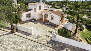 A villa with a courtyard, white walls, and terracotta roof tiles.