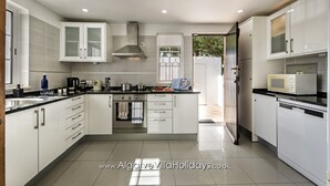 A modern kitchen with white cabinetry, a built-in oven, and a microwave.