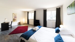 Une chambre d’hôtel moderne équipée d’un grand lit, d’un bureau, d’une chaise et d’une cheminée.