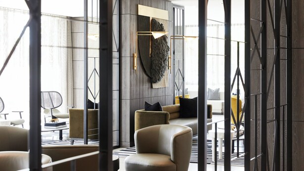A modern interior with a sectional sofa, a coffee table, and a decorative wall piece.