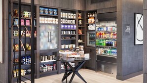 A modern retail space with shelves stocked with snacks, beverages, and packaged goods.