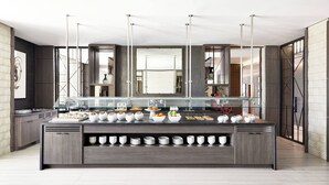 A modern kitchen with a central island, equipped with a glass display case and various kitchen appliances.