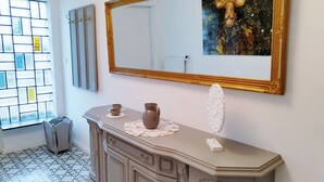 Une salle de bain avec un meuble-lavabo, un miroir et une fenêtre ornée d’un motif géométrique.