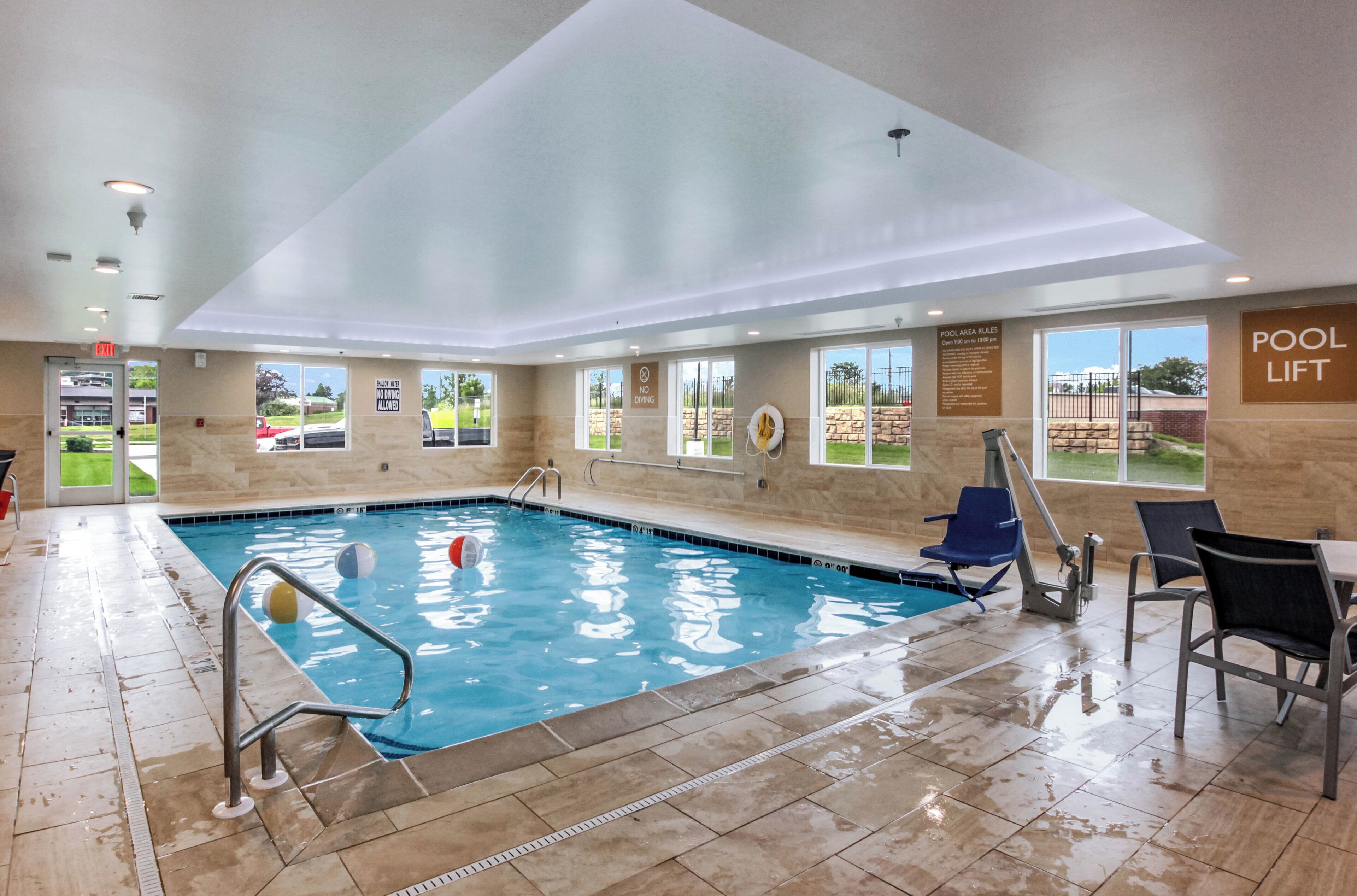 Una piscina techada, sillones reclinables de piscina