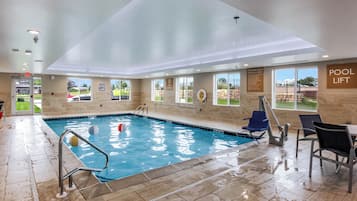 Una piscina techada, sillones reclinables de piscina