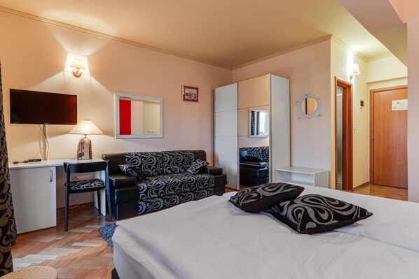 A hotel room with a bed, a desk, a chair, a sofa, and a wardrobe. - Hotel Marinko (Zadar)