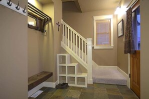 A staircase with white railings, a wooden bench, and a shoe rack.