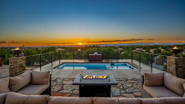 A rooftop pool area with a view of the sunset, stone pillars, and a fire feature. - Amazing Views, Hot Tub, Pool, Sauna, Gourmet Kitchen, Master Suites!  (Santa Fe)
