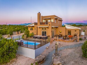 A modern two-story house with a pool, outdoor seating, and a view of mountains. - Amazing Views, Hot Tub, Pool, Sauna, Gourmet Kitchen, Master Suites!  (Santa Fe)