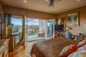 A bedroom with a bed, a desk, a television, and a balcony with a table and chairs. - Amazing Views, Hot Tub, Pool, Sauna, Gourmet Kitchen, Master Suites!  (Santa Fe)