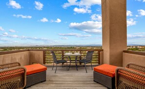 A balcony with wicker furniture, a table, and chairs. - Amazing Views, Hot Tub, Pool, Sauna, Gourmet Kitchen, Master Suites!  (Santa Fe)