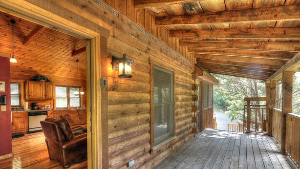 A wooden cabin with a porch, a kitchen area, and a seating area. - Lovesong #9- Charming & Clean Log Cabin!! (Sevierville)