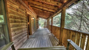 A wooden log cabin with a covered porch and a staircase leading to the entrance. - Lovesong #9- Charming & Clean Log Cabin!! (Sevierville)