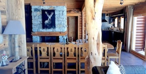 A rustic wooden interior with a stone fireplace, wooden dining table, and chairs. - Les Mélèzes - Very beautiful Chalet 200m from the slopes of La Plagne - 12-15 pers. (Aime-La-Plagne)