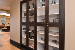 Un espace cuisine doté de meubles et d’étagères en bois, où sont rangés les appareils de cuisine et les ustensiles.