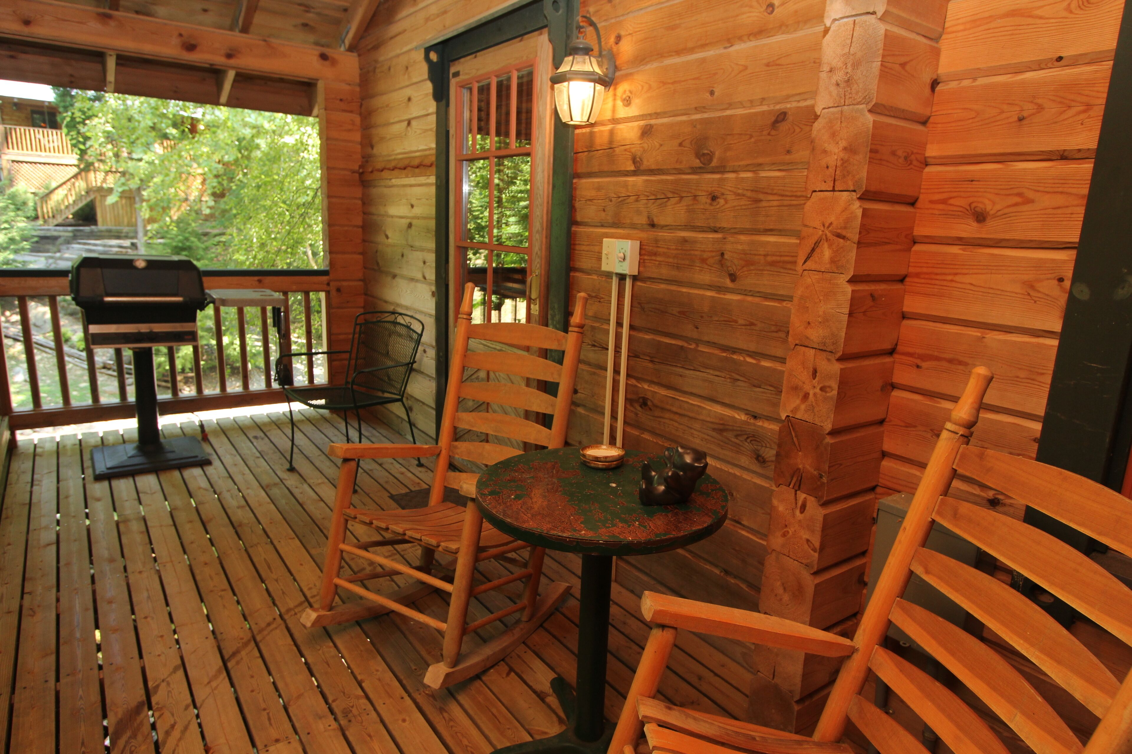 A wooden deck with a table and chairs, a lantern, and a door leading outside.