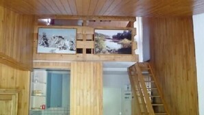 A wooden interior with a loft area featuring framed pictures, a staircase, and a kitchen area. - Tignes Grand Appartement 10p Exceptional View Pied Des Pistes (Tignes)