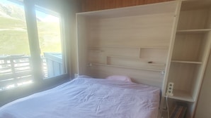 A bedroom with a large bed, a wooden headboard, and a built-in bookshelf. - Tignes Grand Appartement 10p Exceptional View Pied Des Pistes (Tignes)