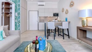 A modern apartment with a living area, kitchenette, and dining space.