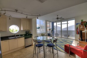 Enjoy a spacious living area with a kitchen, dining table, and large window offering a view of the outdoors.