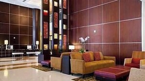 Eine moderne Lobby mit Empfangsschalter, Sitzbereich und dekorativen Wandverkleidungen.