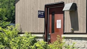 Ein Gebäude mit einem Schild, auf dem 'FIT FITNESS' steht, und einer Tür.