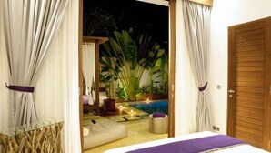 Une chambre avec un lit, une vue sur une piscine et une porte en bois.