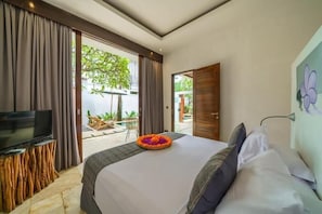 Quarto com cama, televisão e vista para o exterior.