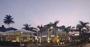 A resort with a glass facade, palm trees, and a sign reading "COUNTRYSIDE Resorts by Meridien."