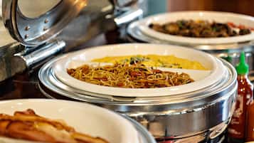 A buffet with various dishes in covered serving dishes.