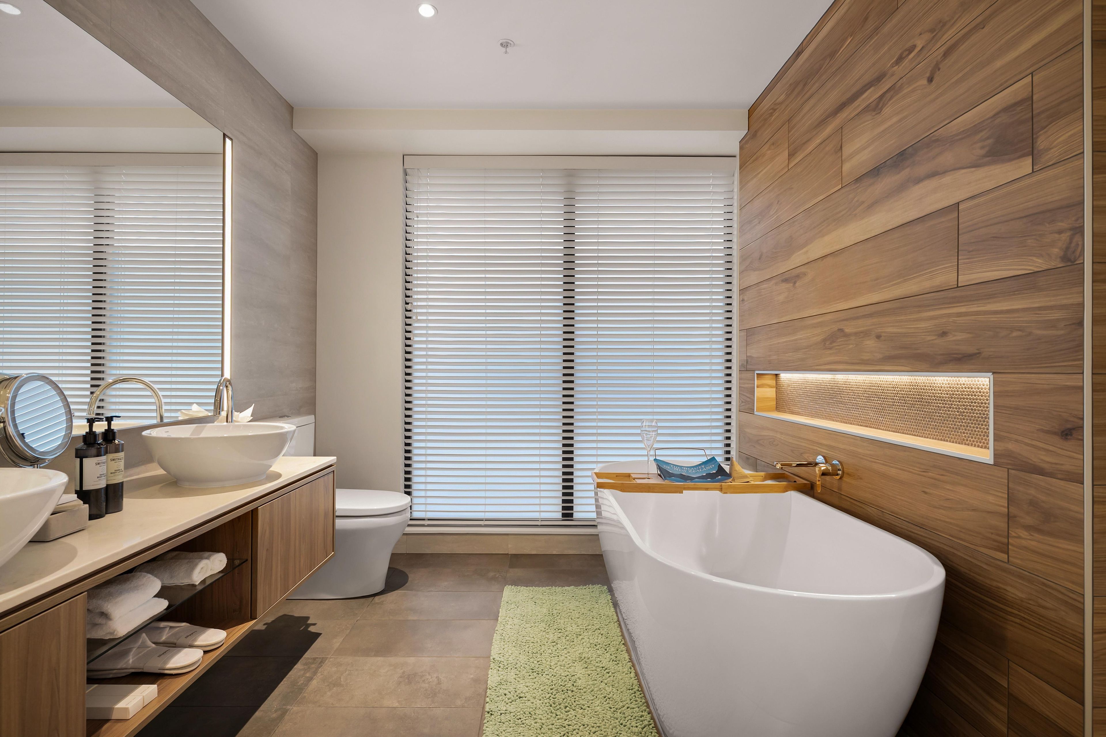 A modern bathroom with a freestanding bathtub, a large mirror, and a vanity with a sink.