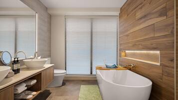 A modern bathroom with a freestanding bathtub, a large mirror, and a vanity with a sink.
