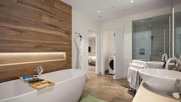 A modern bathroom with a freestanding bathtub, a glass shower enclosure, and a vanity with two sinks.