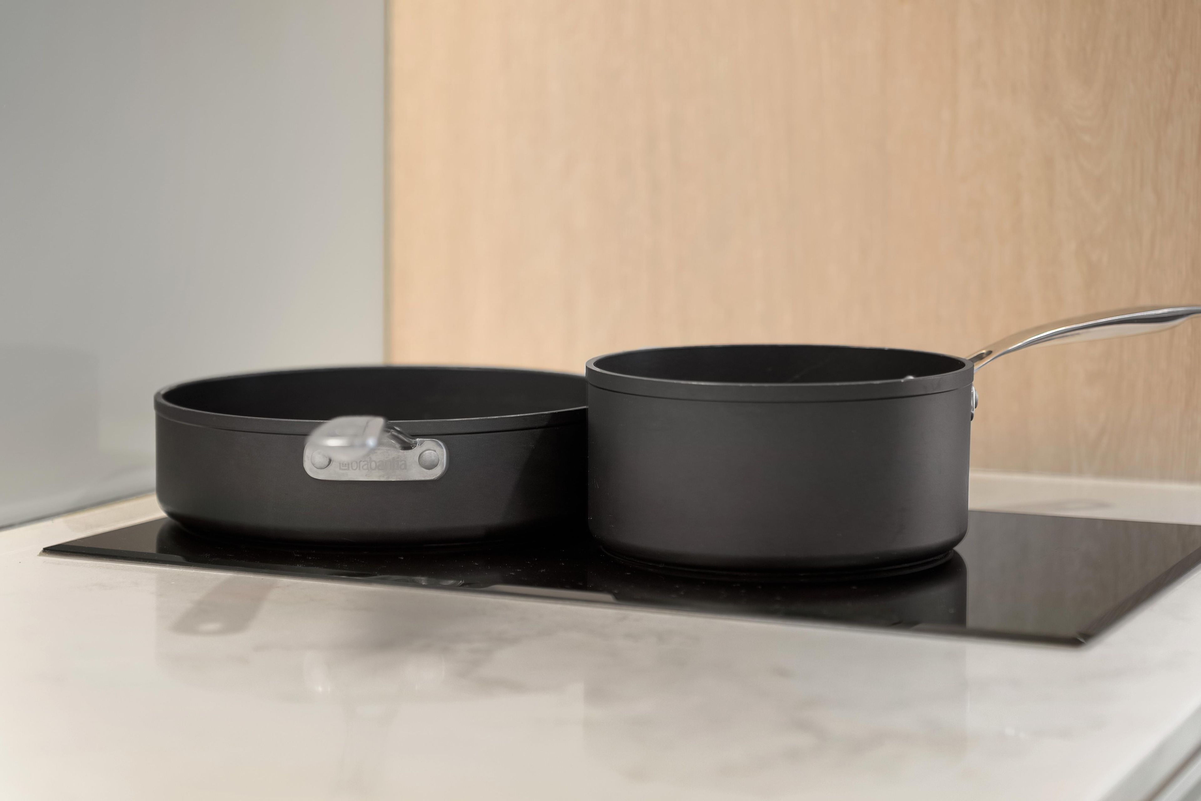 Dos ollas negras sobre una cocina de inducción negra.