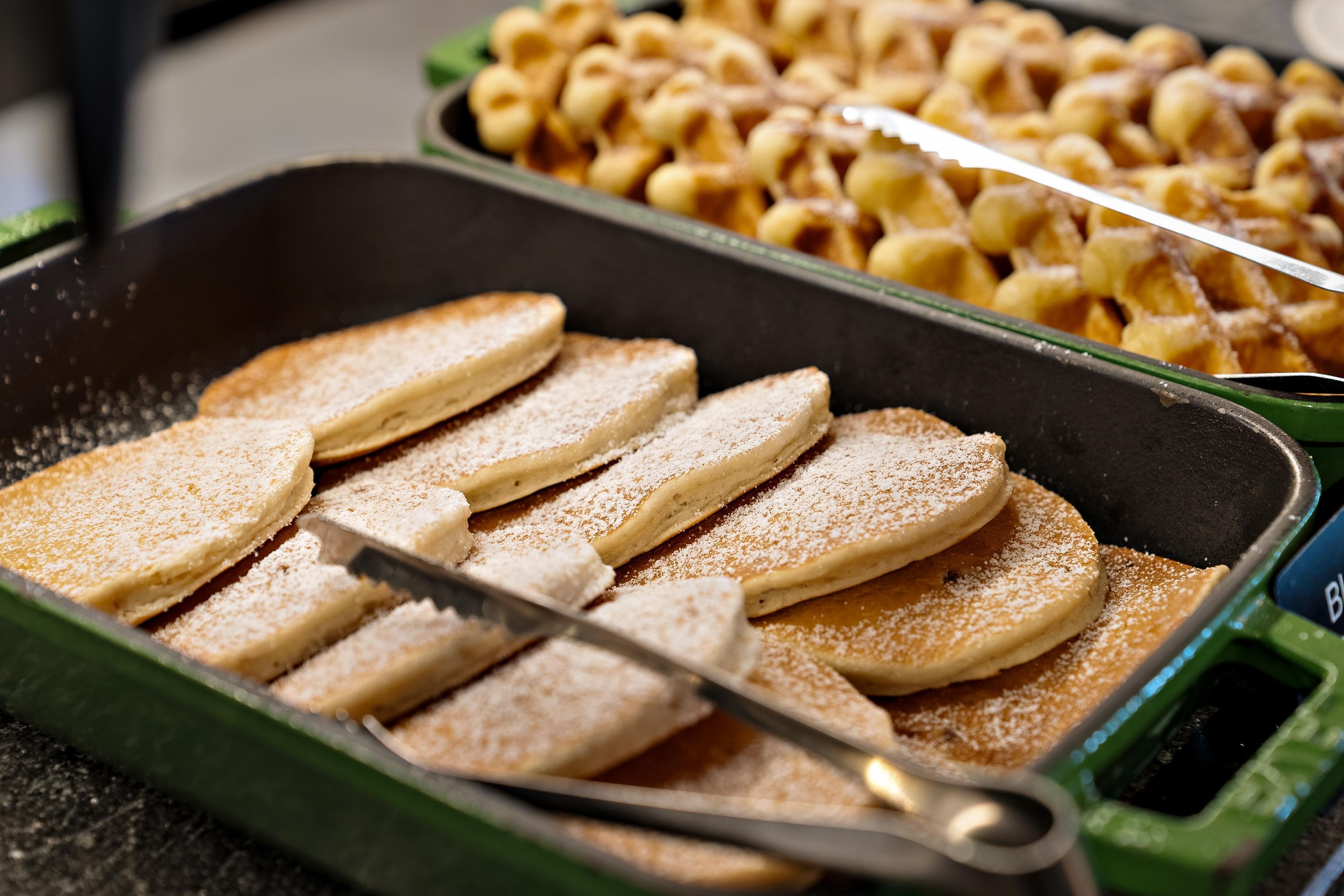 A tray of sliced bread with a dusting of powdered sugar.