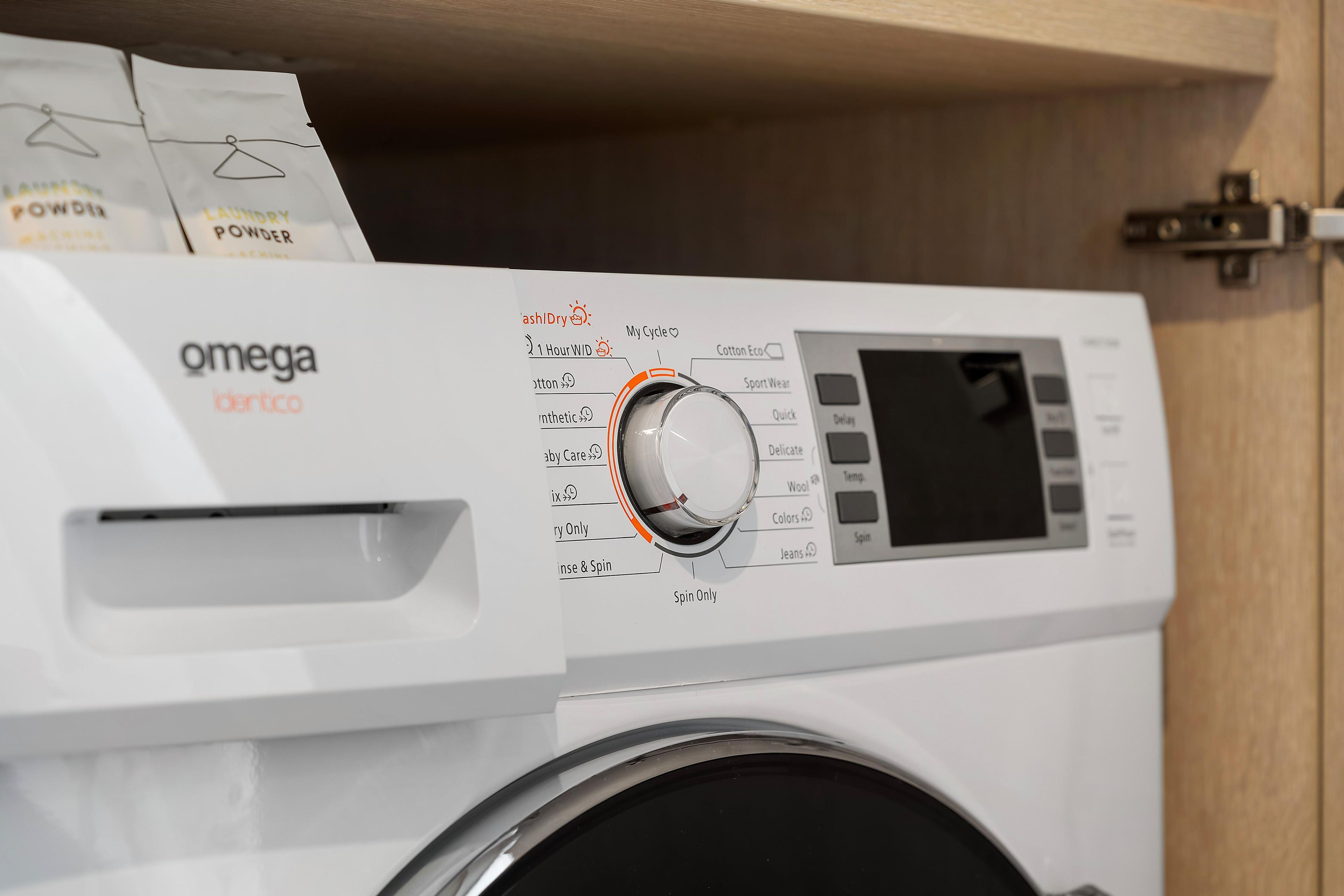 A front view of a white washing machine with a control panel featuring various settings and a digital display.