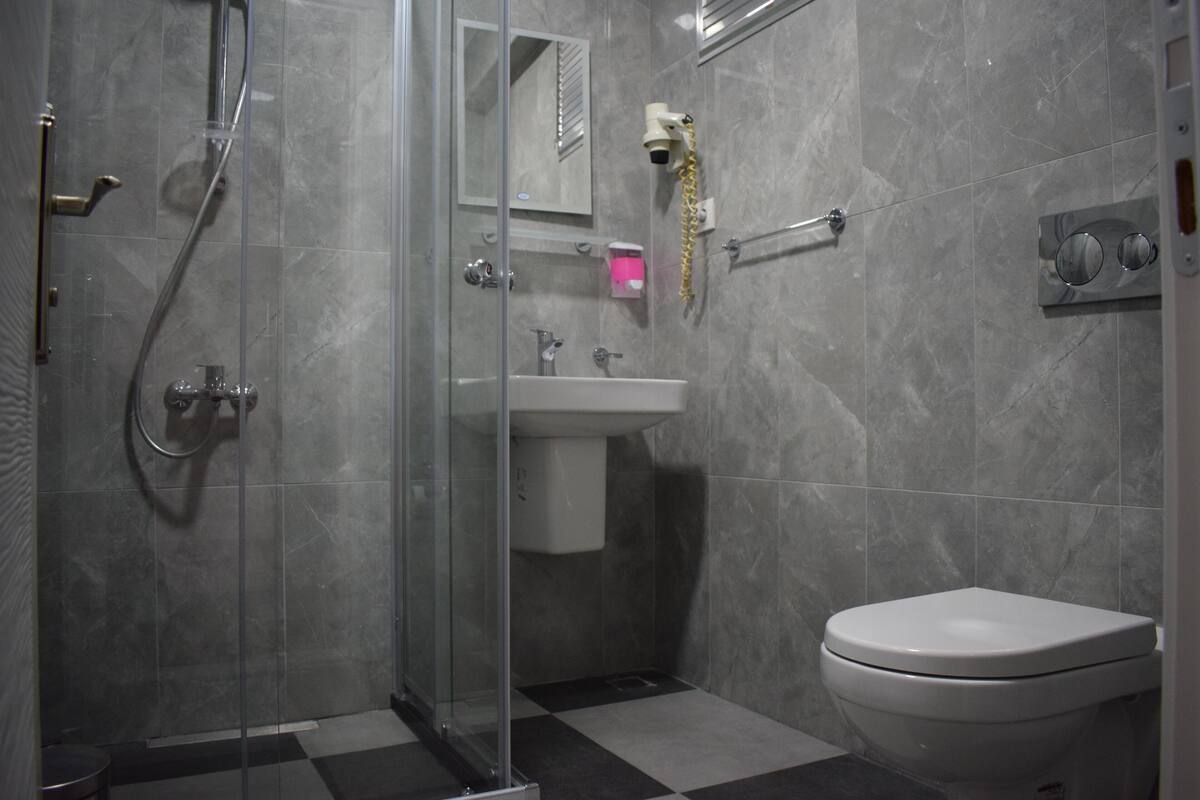 Ein Badezimmer mit Duschkabine, Waschbecken und Toilette.