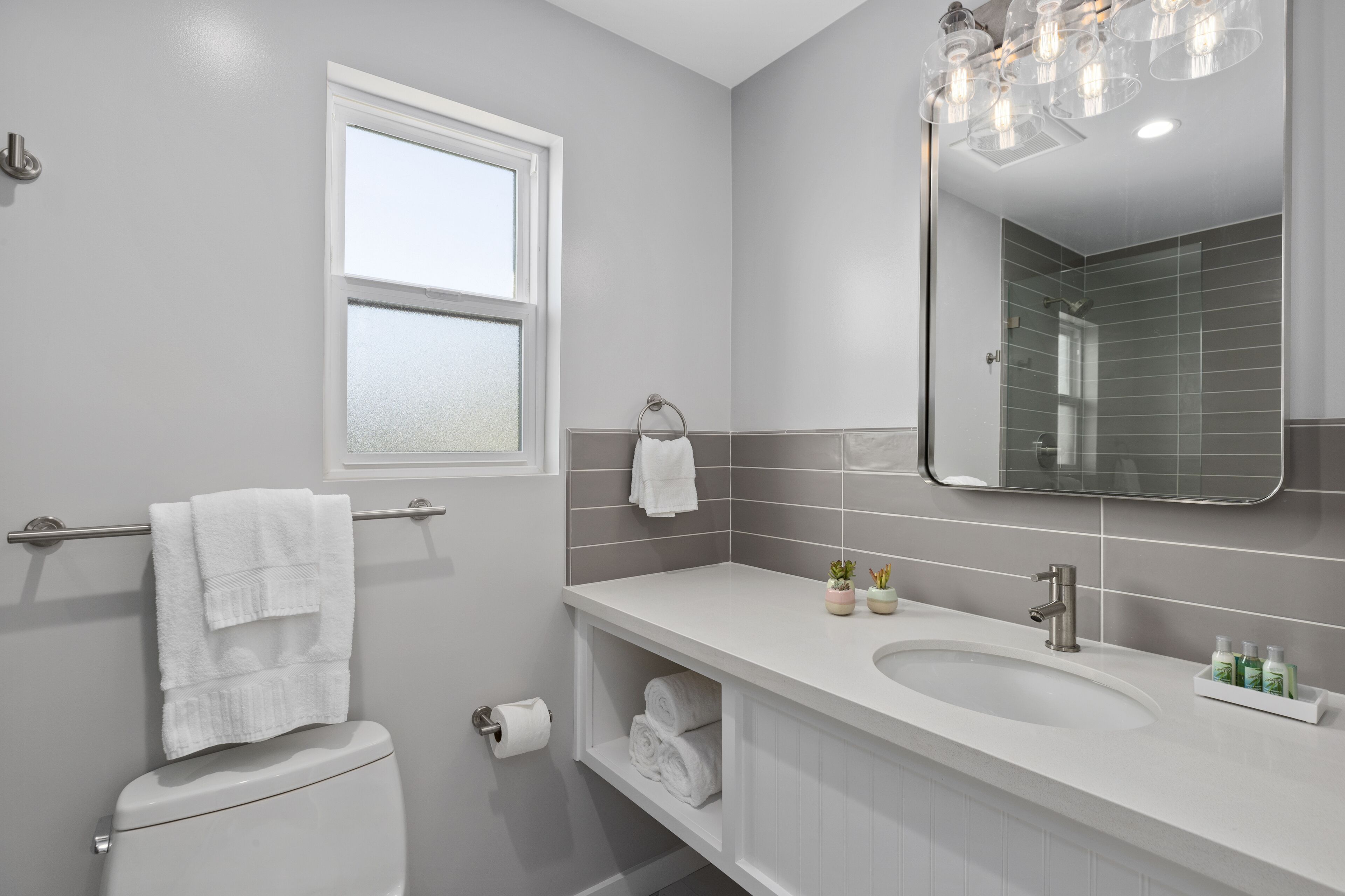 Une salle de bain moderne avec des toilettes, un lavabo et un miroir.