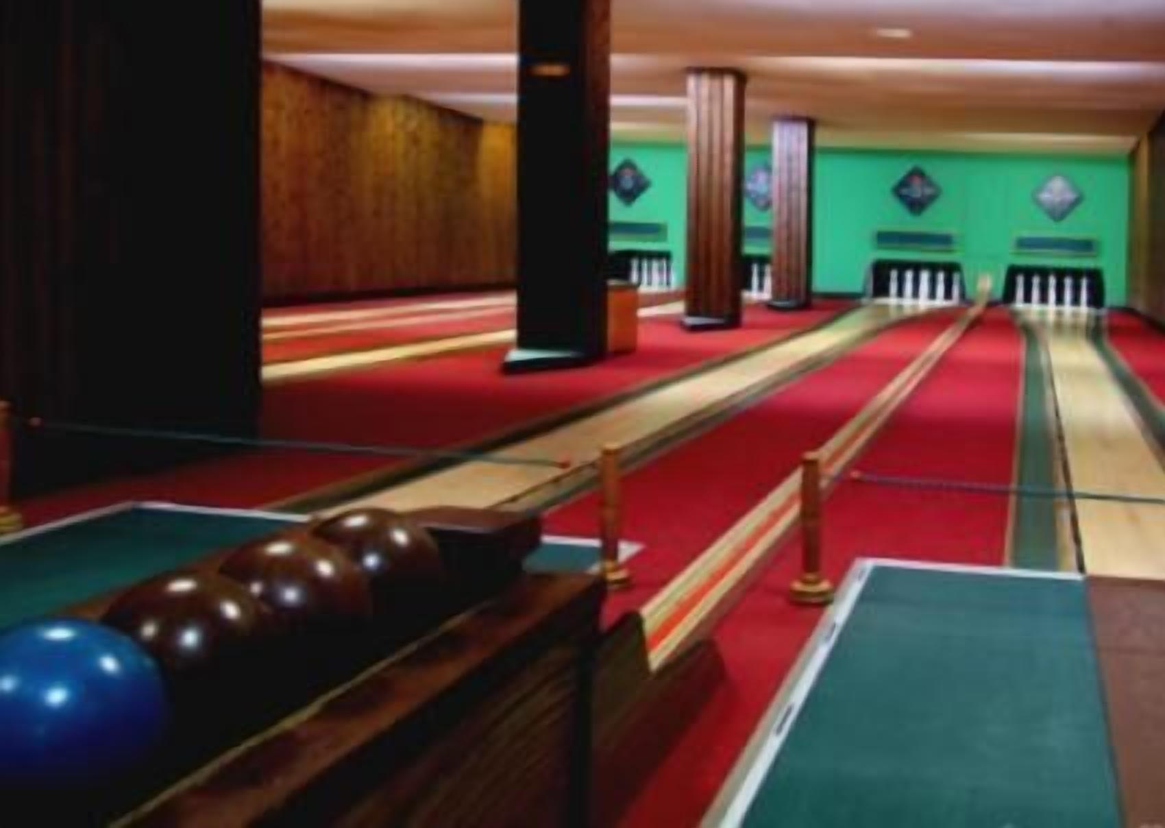 A pool table with balls and a red carpeted area.