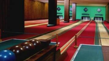 A pool table with balls and a red carpeted area.