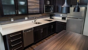 A modern kitchen with dark cabinetry, stainless steel appliances, and a light countertop. - Residence Inn by Marriott Rocklin Roseville (Roseville)