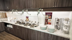 A modern kitchen with dark wood cabinets, a marble countertop, and stainless steel appliances. - Residence Inn by Marriott Rocklin Roseville (Roseville)
