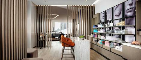 A modern interior with a central bar area, wooden slats, and a display of skincare products.