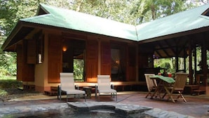 A lodge with a hot tub, outdoor seating, and a covered patio area.