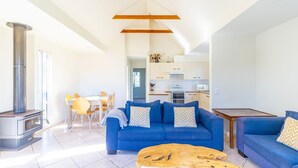 Un salon moderne avec un canapé bleu, une table basse en bois et une cheminée.