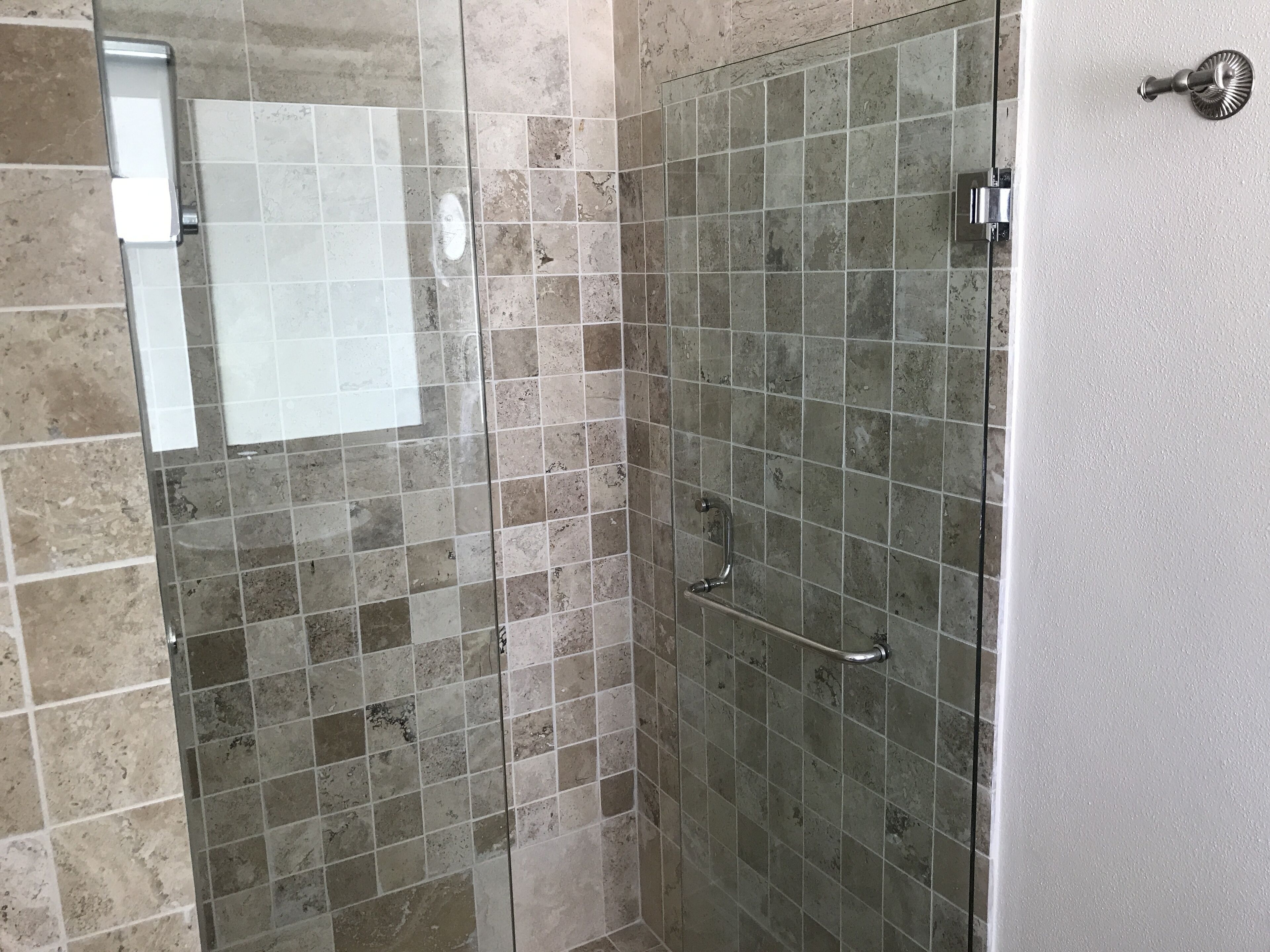 A shower area with tiled walls and a glass door.