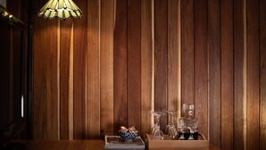 Een houten wandpaneel met een tafel waarop een kom, glazen en een dienblad staan.