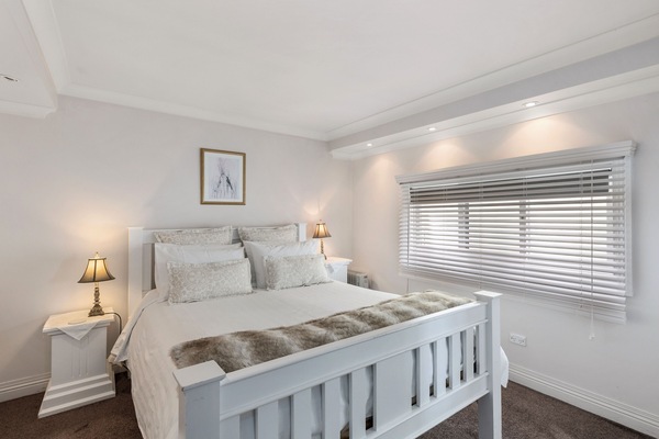 Ellie's Spa Cottage bedroom, beautiful bedding and soft lighting.